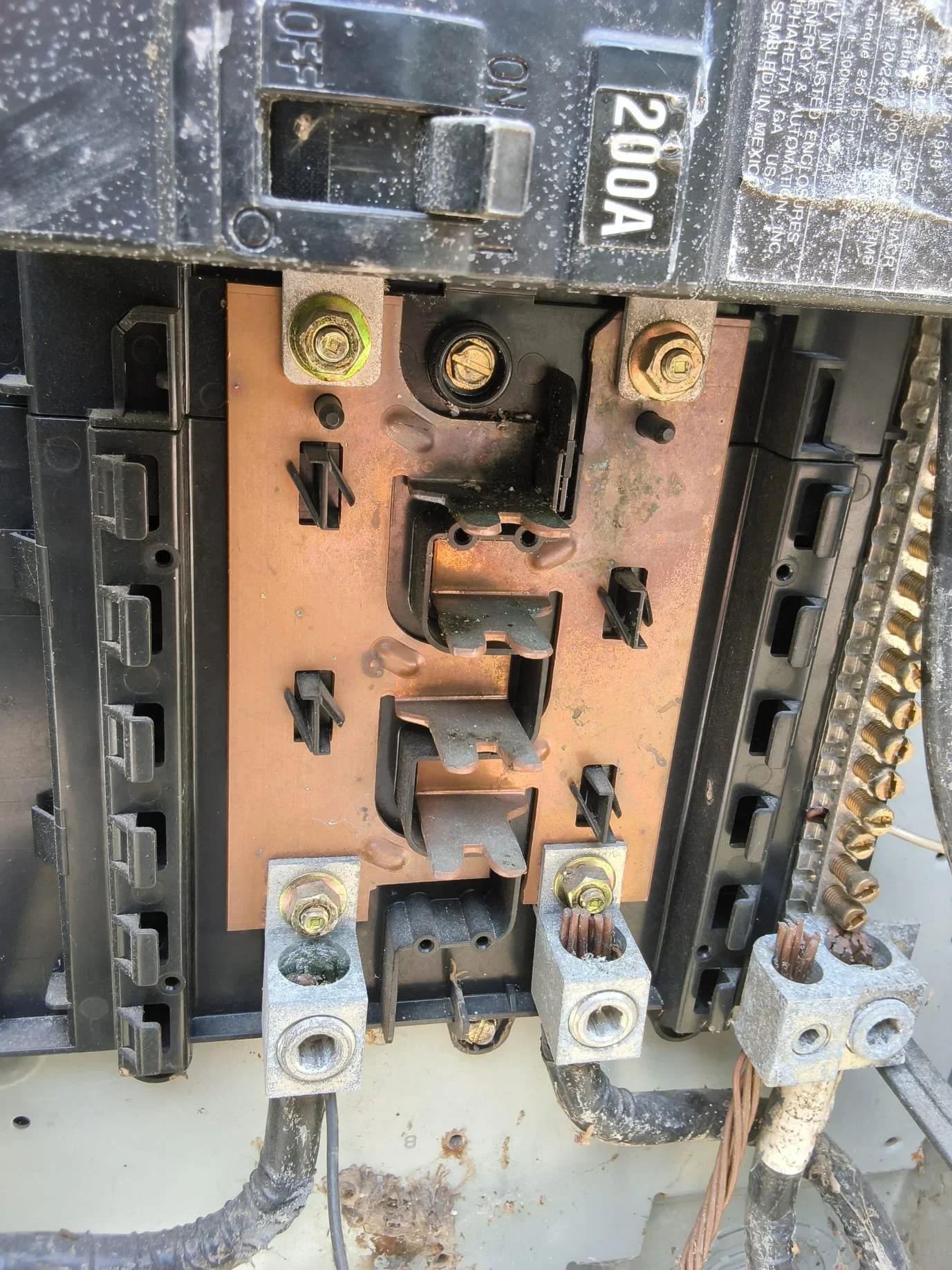 200-amp electrical service panel with copper bus bars, brass terminal lugs, and circuit breaker slots
