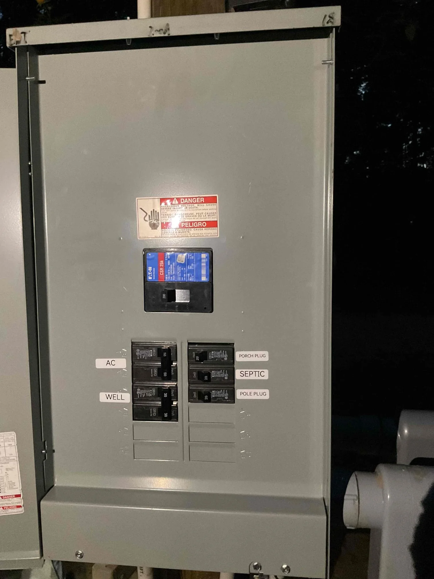 Gray electrical panel with multiple circuit breakers, main disconnect, and labeled circuits for residential systems
