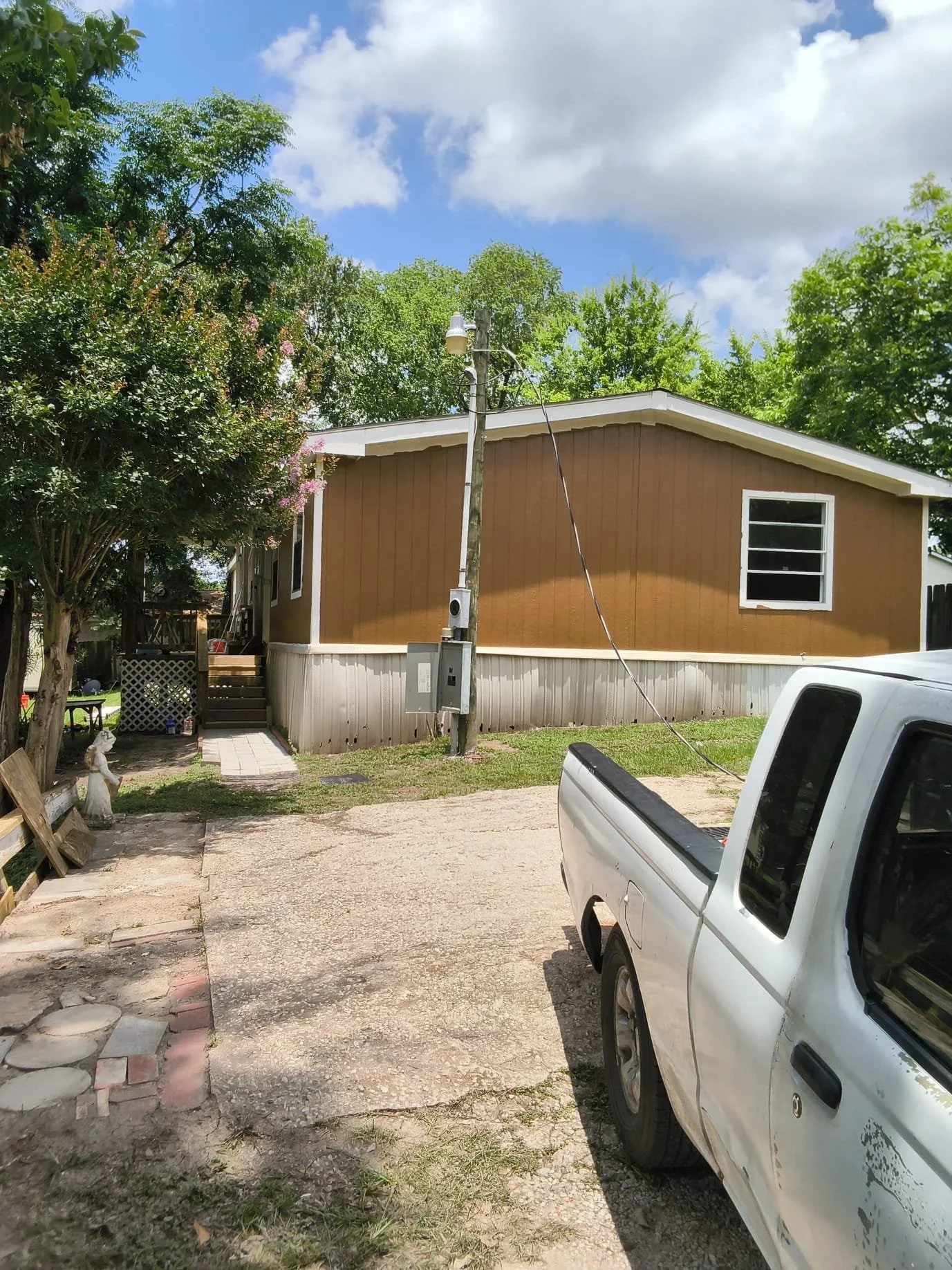 Mobile home with electrical meter and overhead service lines installed on utility pole