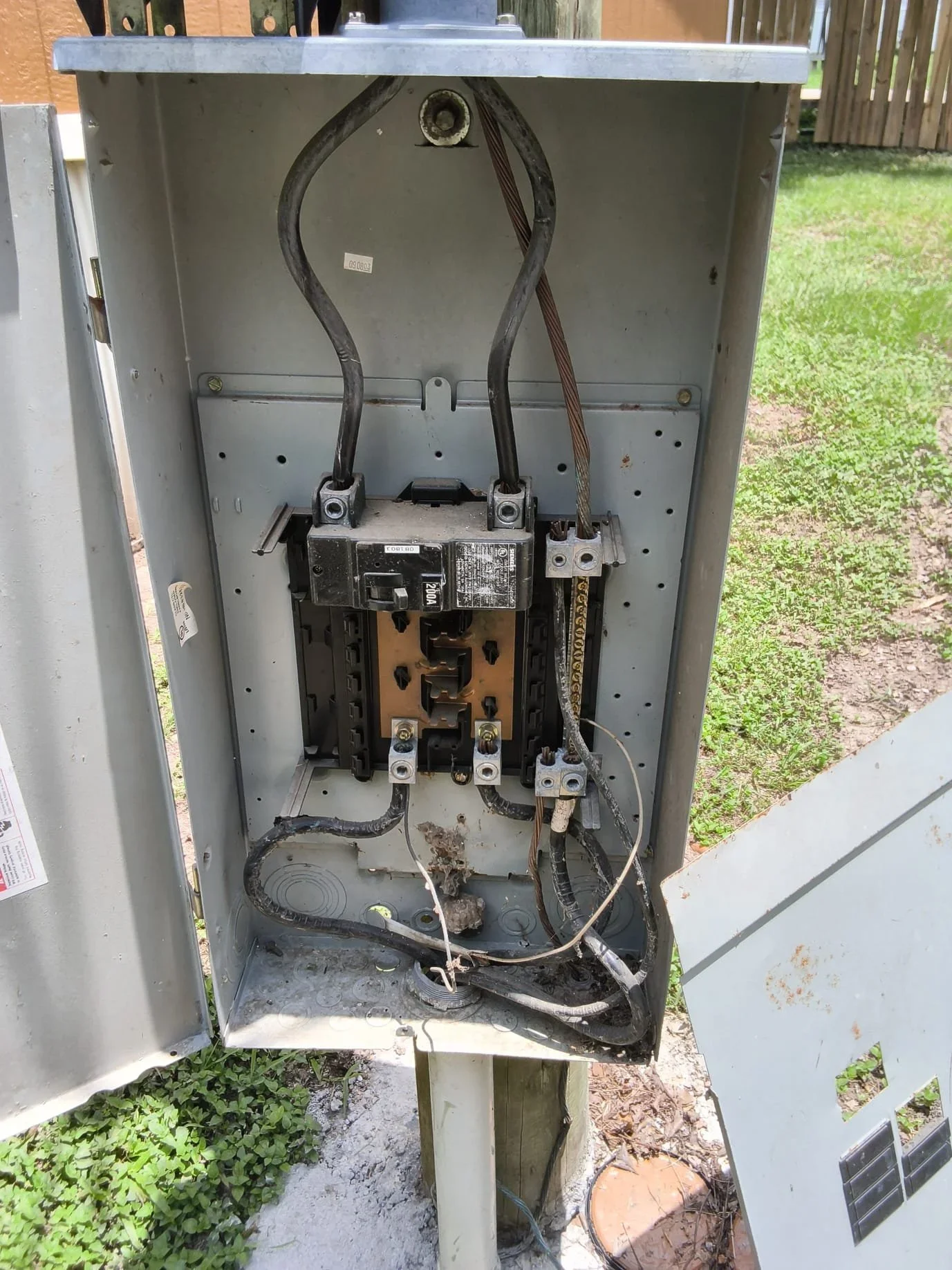 Interior view of electrical panel with main breaker, copper bus bars, and organized wire connections